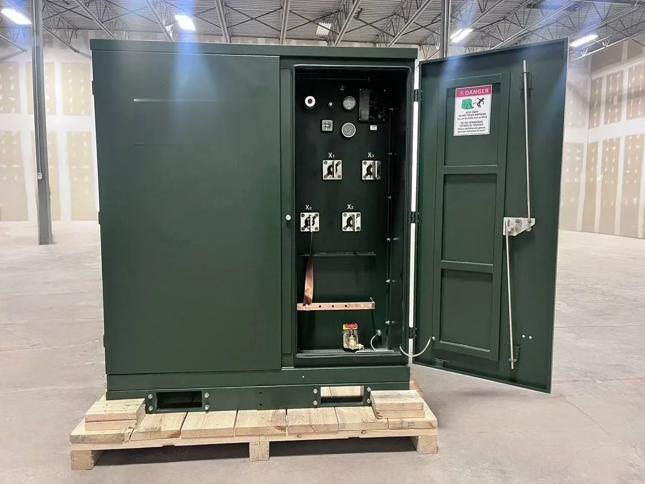 Reconditioned pad-mount transformer on a shipping pallet, inspection door open — tested and ready to ship